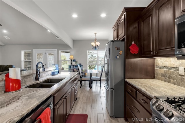 kitchen with tasteful backsplash, sink, beam ceiling, an inviting chandelier, and stainless steel appliances