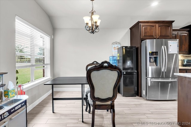 kitchen with pendant lighting, dark brown cabinets, stainless steel fridge with ice dispenser, a notable chandelier, and vaulted ceiling