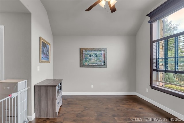 empty room with ceiling fan, lofted ceiling, and dark hardwood / wood-style floors