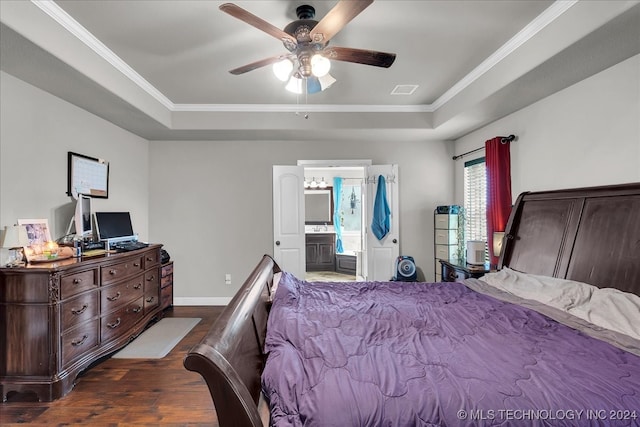 bedroom with ceiling fan, dark wood-type flooring, a raised ceiling, and ensuite bathroom