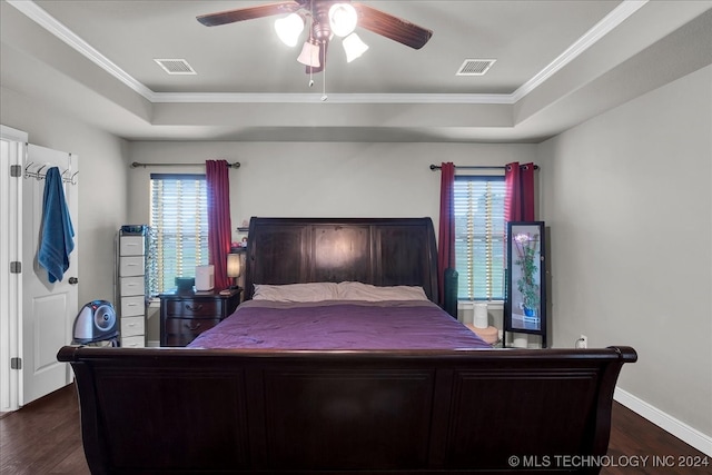 bedroom with ceiling fan, a tray ceiling, crown molding, and dark hardwood / wood-style flooring