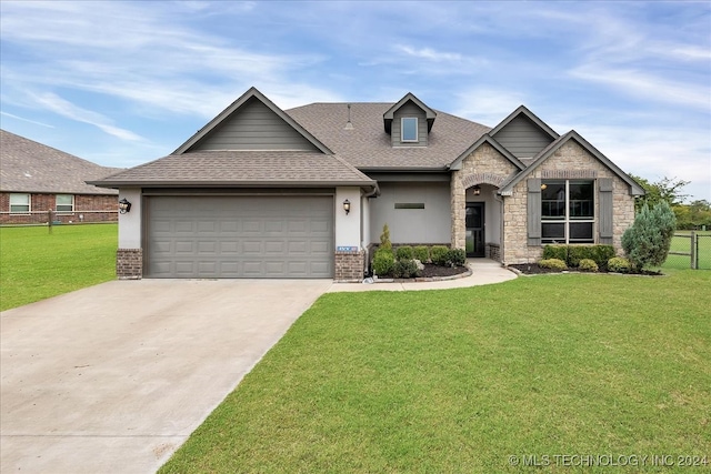 view of front of home with a front yard and a garage