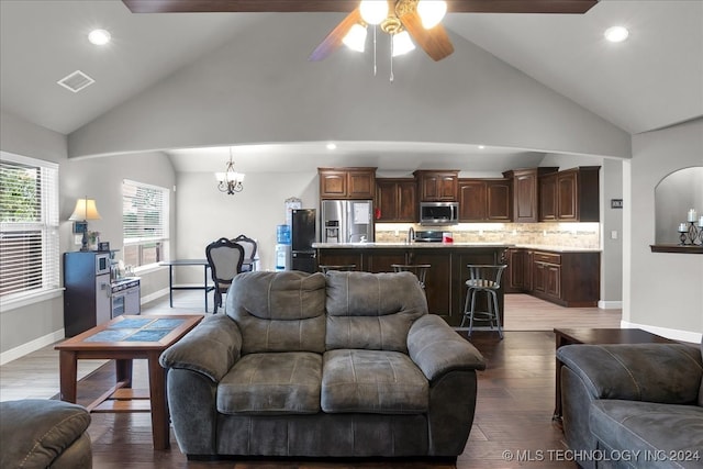 living room with hardwood / wood-style flooring, ceiling fan with notable chandelier, and high vaulted ceiling