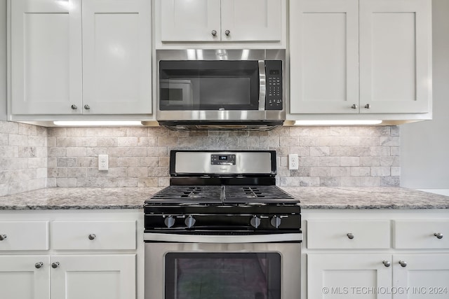 kitchen featuring light stone counters, white cabinets, stainless steel appliances, and tasteful backsplash