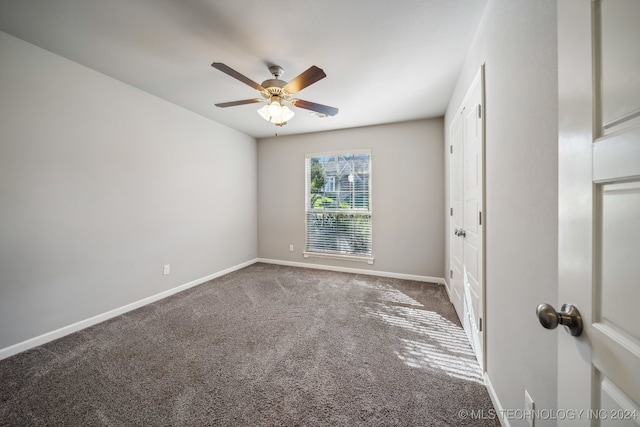 carpeted spare room with ceiling fan