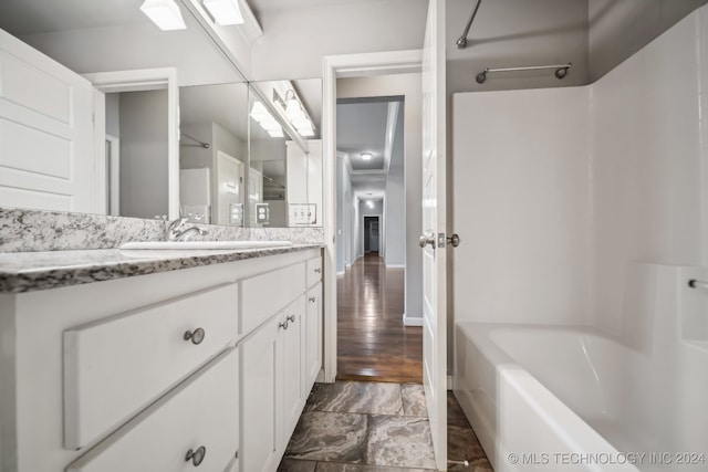 bathroom with shower / bathtub combination, vanity, and hardwood / wood-style floors