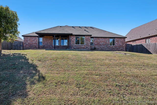 rear view of house featuring a yard