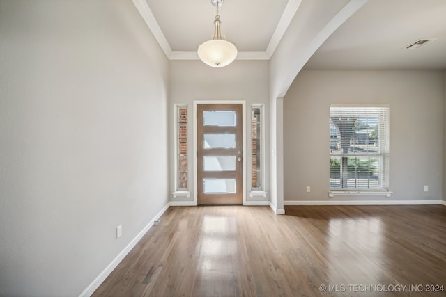 foyer with wood-type flooring and ornamental molding