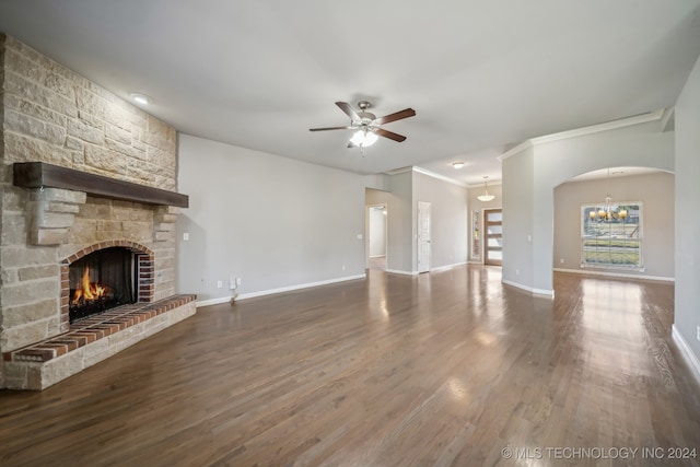 unfurnished living room featuring wood-type flooring, a fireplace, crown molding, and ceiling fan