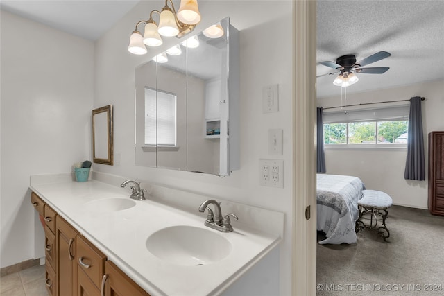 bathroom featuring ceiling fan, vanity, and a textured ceiling