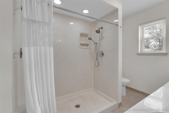 full bathroom with toilet, tile patterned floors, and a shower stall