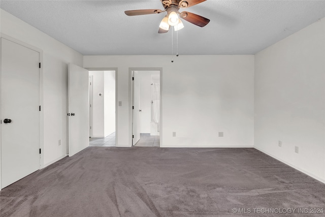 unfurnished bedroom featuring a textured ceiling, ensuite bathroom, ceiling fan, and light colored carpet