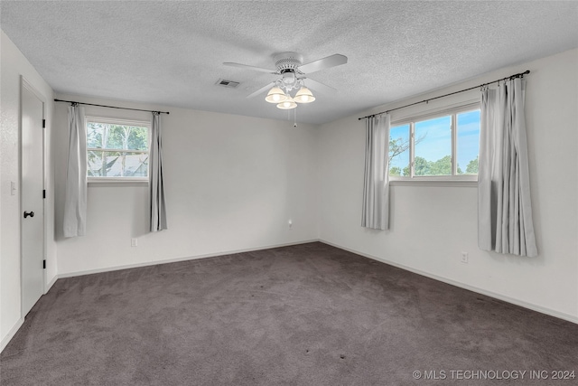 unfurnished room with visible vents, baseboards, ceiling fan, carpet, and a textured ceiling