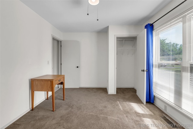 unfurnished bedroom featuring light carpet and a closet