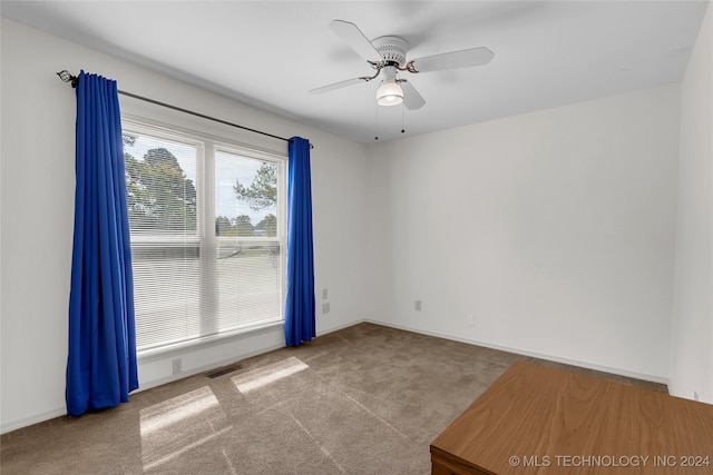 carpeted spare room featuring ceiling fan