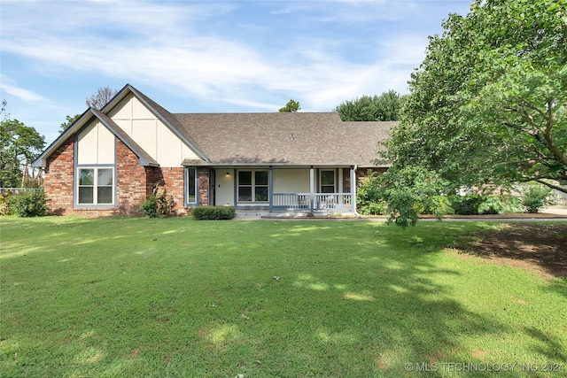 view of front of home featuring brick siding, a front lawn, a shingled roof, and a porch