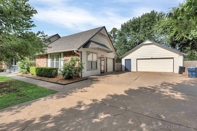 view of front of home with fence, an outdoor structure, a garage, and roof with shingles