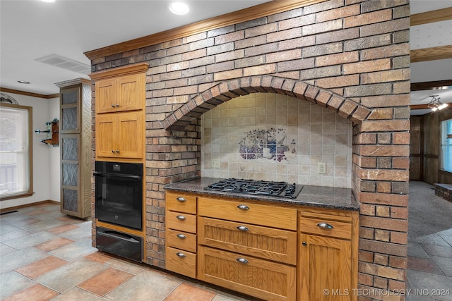 kitchen with dark stone counters, gas stovetop, a warming drawer, black oven, and backsplash
