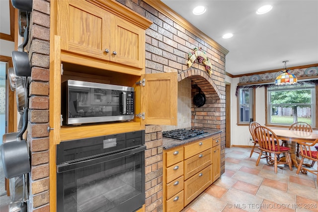 kitchen featuring ornamental molding, black appliances, and hanging light fixtures