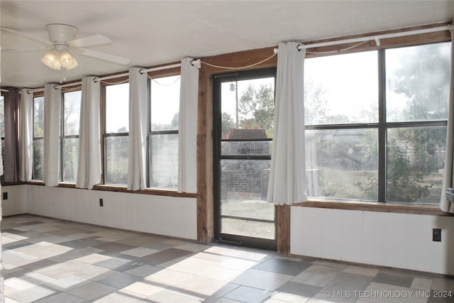 unfurnished sunroom featuring a wealth of natural light and ceiling fan