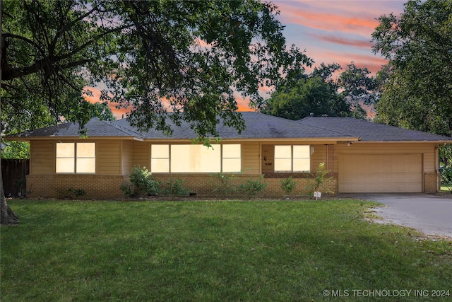 single story home with a garage and a lawn