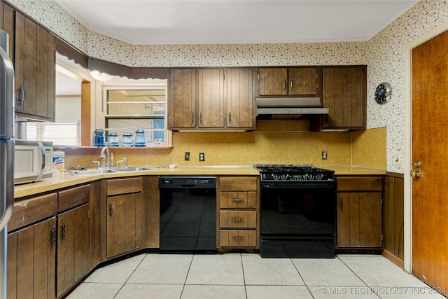 kitchen featuring black appliances, crown molding, light tile patterned flooring, and sink