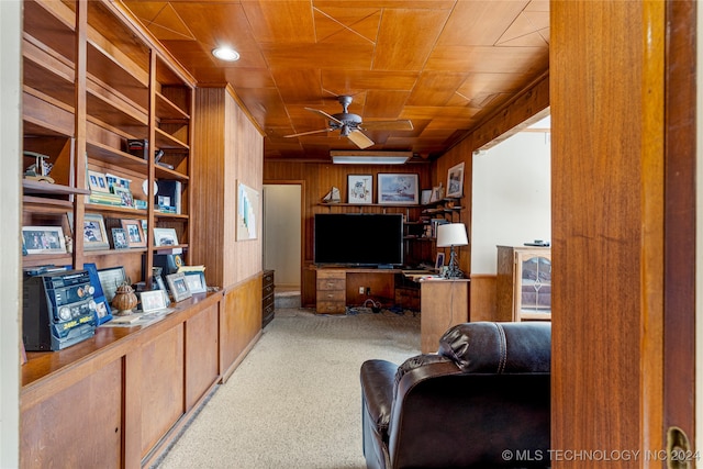 carpeted home office featuring wood ceiling, wood walls, and ceiling fan