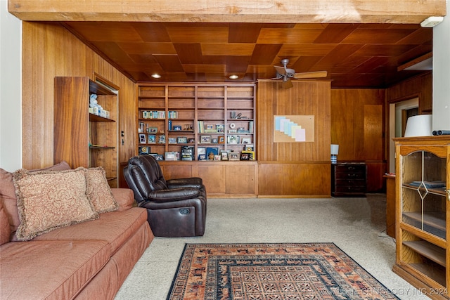 living room with wood ceiling, built in shelves, wooden walls, and ceiling fan