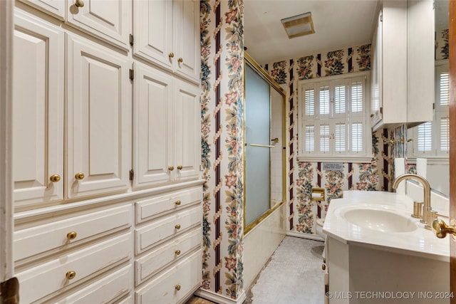 full bathroom featuring toilet, vanity, and combined bath / shower with glass door