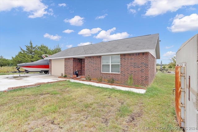 ranch-style house with a front lawn and a patio