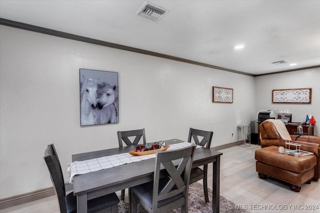 dining space featuring crown molding and light hardwood / wood-style floors