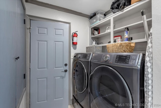 washroom featuring ornamental molding and washing machine and clothes dryer