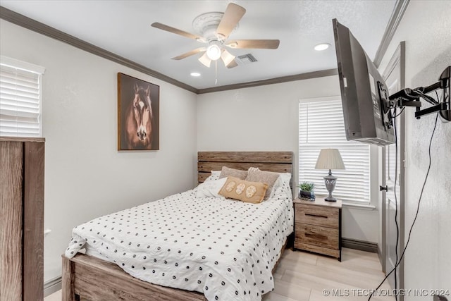 bedroom featuring light hardwood / wood-style floors, ornamental molding, and ceiling fan