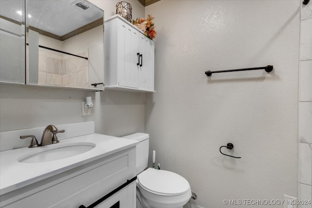 bathroom with walk in shower, crown molding, vanity, and toilet