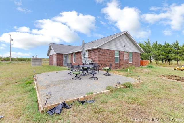 back of house with a patio and a lawn