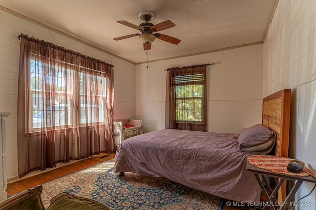 bedroom with ornamental molding, ceiling fan, and hardwood / wood-style floors