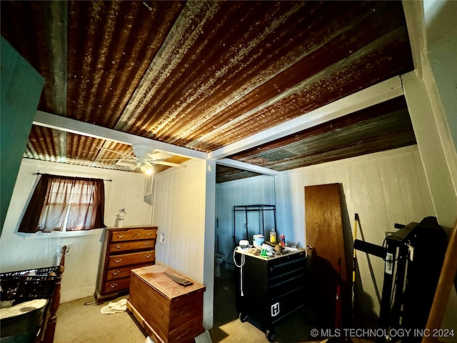 interior space featuring wooden walls and ceiling fan