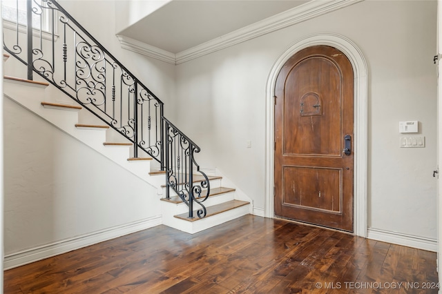 foyer entrance with ornamental molding and dark hardwood / wood-style floors