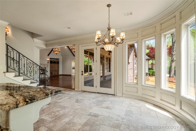 interior space with ornamental molding, an inviting chandelier, and plenty of natural light