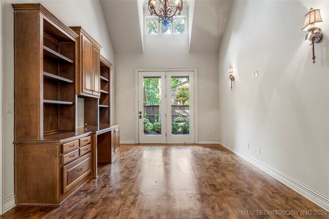 unfurnished office with french doors, lofted ceiling, a chandelier, and dark wood-type flooring