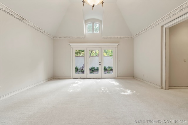 carpeted spare room with french doors and high vaulted ceiling