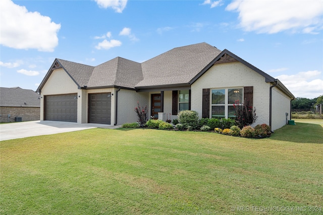 view of front of property with roof with shingles, an attached garage, a front lawn, concrete driveway, and brick siding