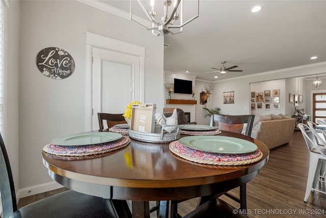 dining room with crown molding, wood finished floors, a fireplace, and recessed lighting