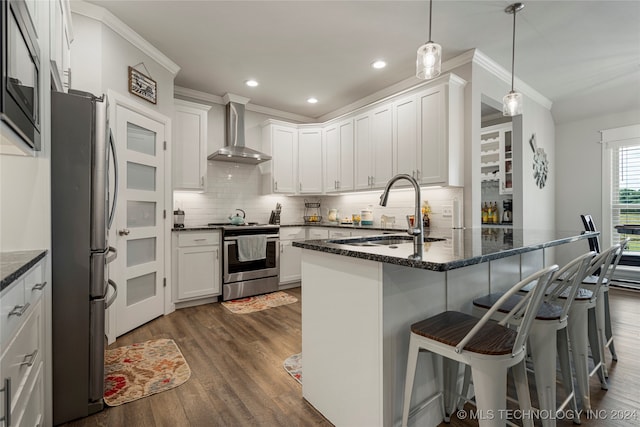 kitchen featuring stainless steel appliances, sink, wall chimney range hood, and white cabinetry