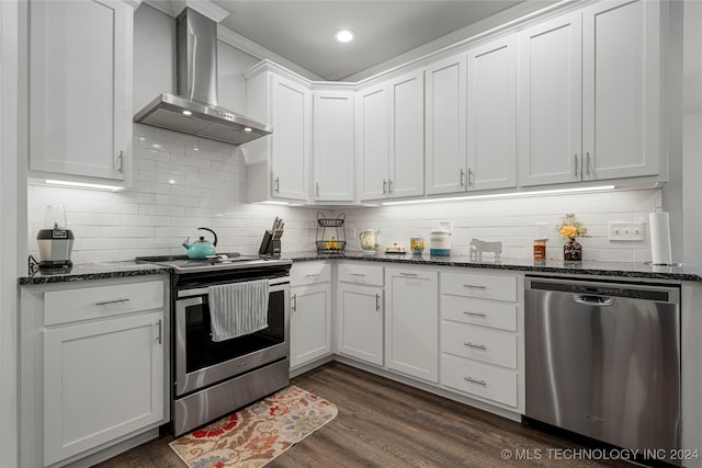 kitchen featuring white cabinets, wall chimney range hood, decorative backsplash, stainless steel appliances, and dark hardwood / wood-style flooring