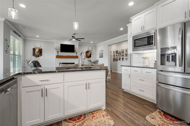 kitchen with dark wood-type flooring, ornamental molding, tasteful backsplash, and stainless steel appliances