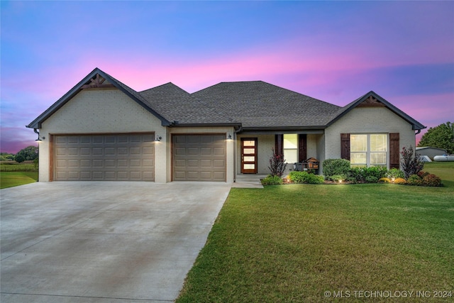 view of front of home with driveway, brick siding, an attached garage, and a lawn