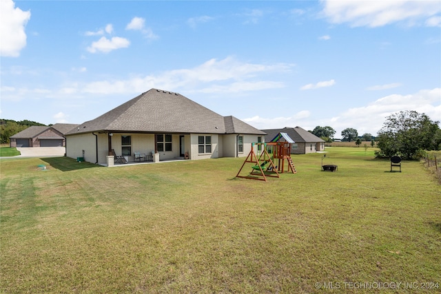 rear view of house featuring a patio area, a playground, a lawn, and roof with shingles