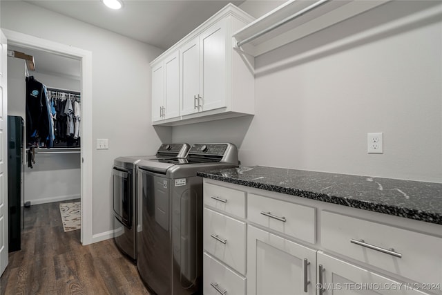 washroom featuring separate washer and dryer, dark wood-type flooring, and cabinets