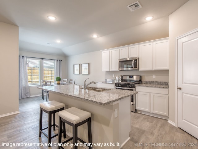 kitchen with appliances with stainless steel finishes, a center island with sink, white cabinetry, and sink